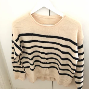 Randig tröja - Krämvit randig tröja med slits längst ut på armen. Använd 1 gång, nyskick!