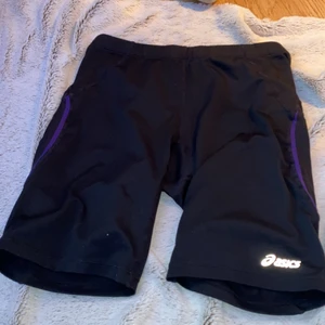 Svarta cykelbyxor  - Svarta cyxkelbyxor träningmatreal, lila detaljer storlek M 