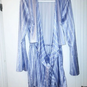 Playsuit från NLY - Jättefin playsuit med knytning framtill. Ljusblå/randig i glansig nyans. Perfekta outfiten till sommaren. Kan mötas eller så står köpare för frakt.