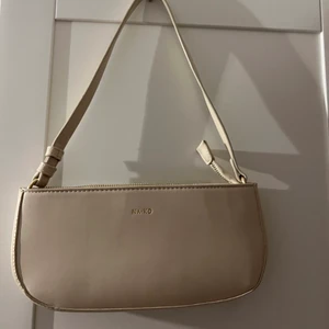 Väska från NAKD  - Säljer denna beiga väska från Nakd, sparsamt använd och nästan som ny. Säljer för 80 kr + frakt ( köparen står för frakten ) 