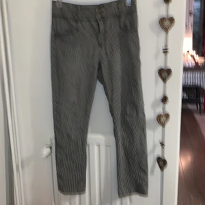 Randiga byxor - Svart och vitrandiga byxor med högmidja. Från märket Flash Jeans, förmodligen från 90-talet. Tre knappar vid gylfen och väldigt mjukt material