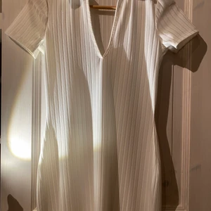 Vit ribbad klänning från Nelly - Vit ribbad kort klänning från nelly One, storlek xs, V-ringad med krage och sitter väldigt snyggt, den är lite genomskinlig så funkar bara med hudneutrala underkläder. Aldrig använd endast provad!