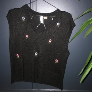 Svart väst med blommor - Jättegullig väst från hm som tyvärr inte längre kommer till användning. Västen är använd sparsamt och den är i mycket bra skick! Köparen står för frakten eller så kan jag mötas upp i Stockholm. 