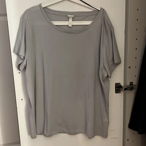 Ljusgrå T-shirt - En ljusgrå avslappnad T-shirt från H&M i storlek XL, aldrig använd