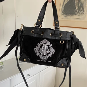 Juicy Couture väska - Äkta Väska från Juicy Couture köpt i USA. Inte jättestor men väldigt rymlig. Är osäker på om det är den lilla versionen eller mellan men om jag spretar på min hand och håller den framför så är den ungefär lika hög som min hand då.