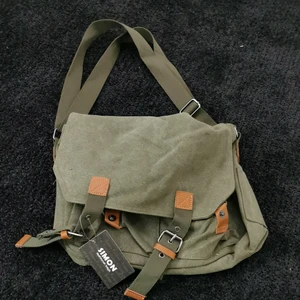 Väska - En helt ny militärgrön axelremsväska. Lappen finns kvar. Kontakta för fler bilder, om ni är intresserade eller har frågor❤️man kan ändra längden på remmarna. Många fack. 