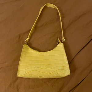 Superfin sommarväska - Säljer denna helt oanvända gula väskan! Jättefint ”krokodilmönster” och guldiga detaljer på dragkedjan etc. Skriv om du vill ha fler bilder :)