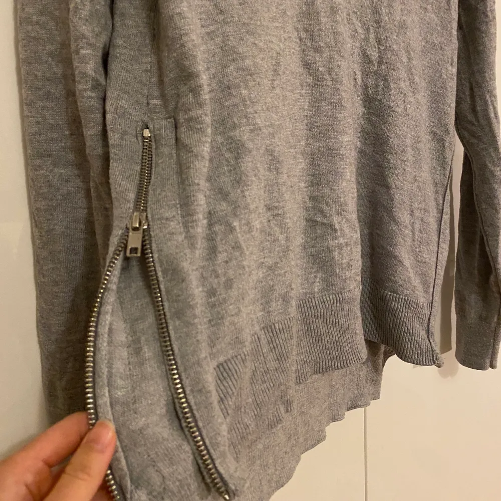 Superskönt stickad grå tröja med snygga dragkedjor på sidan. Stickat.