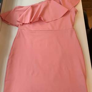 En hyfsat ny klänning, använd endast en gång. Passar perfekt för evenemang av olika slag. I en fantastisk rosa färg. One shoulder 