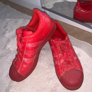 Röda adidas superstar - Röda adidas superstar med mönster i reflex. I gott skick.