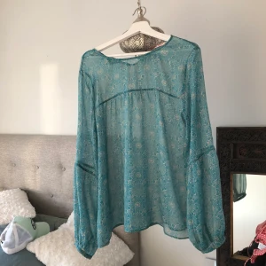 Blus från Indiska  - Blus från Indiska, ljusblå med mönster som blommor ungefär. Använd Max 4 gånger, bra skick. Super skönt material verkligen! Den är lite genomskinlig. Den är i storlek Xl, men passar s och m. 