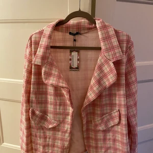 Rutig kavaj  - Snygg rutig kavaj i fina färger, är mer rosa i verkligheten. Ska vara i stl 46 men känns lite mindre men är i väldigt stretchigt tyg. Oanvänd med lappen kvar. 