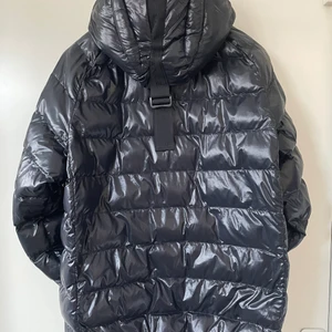 Vinterjacka från Peak Performance  - Snygg svart vinterjacka med luva från Peak Performance strl M. Luvan har haft ett litet hål som precis lagats av skräddare (280:-j men i övrigt i nyskick. Ord pris 2995:-