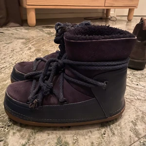 Inukii  - Säljer mina mörkblåa inukkis i ok/bra skick, verkligen så sköna och coola vinterskor som passar till alla outfits                   Defekter som att ena banden att tuffasts upp lite samt att jag i ena skon har klippt bort vadderingen längs hälsenan då det skavde 