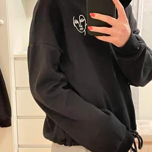 INTRESSEKOLL 🎉  Svart hoodie från Gina tricot köpt 2020 men knappt använd. Hoodien är ganska tunn och har en tunn luva, hoodie har även ett ansiktstryck men också snören för att spänna tröjan. Köpt för 299 kr🧚🏼‍♀️