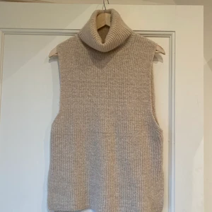 Stickad polotröja utan ärmar - Snygg beige polo utan ärmar, jätte snyggt att ha en vit skjorta under! Jätte mjukt matrial.