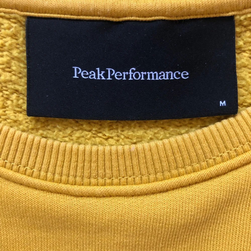 Det är en gul Peak Performance sweatshirt som jag köpte för ungefär 3 år sen. Fint skick, lite använd. Storlek medium. Köpte den för 1000 kr.. Hoodies.