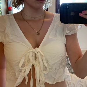 Hansydd fronttie topp - Egensydd vit topp som knyts framtill med volangärmar ich volangdetalj längs med botten. Sytt själv men kommer ej till användning tyvärr!