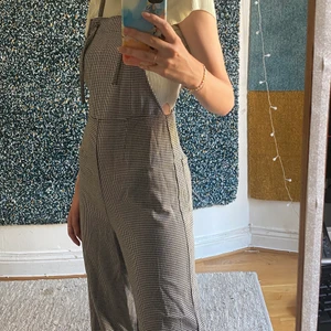 Jumpsuit Svart Vit  - Svart vit jumpsuit från monki i storlek S. Den har dragkedja på sidan och band man kan ändra längd på genom att knyta om knutarna på framsidan. Kan mötas upp i Stockholm annars står köparen för frakt. 