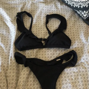 Aimn bikini - Ribbad svart bikini från Aimn med volanger, i storlek S. Grymt bra kvalitet och den är väldigt bekväm. Fick av min mamma då den inte passade henne men har aldrig fått användning utav den. Lappar är borttagna men den är som ny🌺 Säljes för 300 inkl frakten💘 Nypris för bikinin ligger runt 600 kr!
