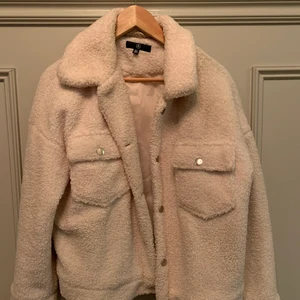 Vit lurvig jacka - Mysig lurvig/fleece liknande jacka från missguided. Vit med fina detaljer och knappar som knäppning. Lite oversized i modellen så passar XS till M. Storlek 