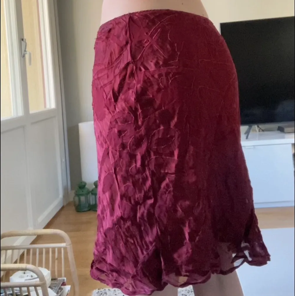 Vinröd kjol (typ satin material?) med tryck som ska likna blommor?  jag köpte kjolen på Humana i somras men den blev aldrig till användning:-( Frakt 37❣️☺️. Kjolar.