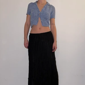 Lång svart kjol - Långkjol i skrynkligt shiny material. Resår i midjan, man kan ha den sittandes lågt på höften eller över höften. Funkar ev för en strl M också