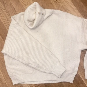 Stickad tröja med knappar - Vit stickad tröja med polokrage samt knappar på kragen. Lite oversized modell. Storlek S.