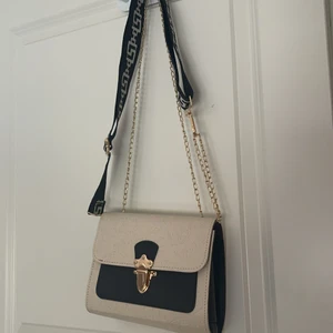 väska - svart & beige väska. det svarta bandet har jag satt på själv men de går att ta av om man ej vill ha det. (+30kr för bandet.) aldrig använd. 