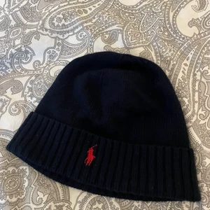 Ralph lauren mössa/beanie  - Säljer min jättefina marinblåa ralph lauren mössa med det röda märket som är köpt för 499kr. Priset kan diskuteras! Den är i väldigt gott skick då den knappt är använd! Passar förövrigt både tjejer och killar. Kontakta vid intresse!