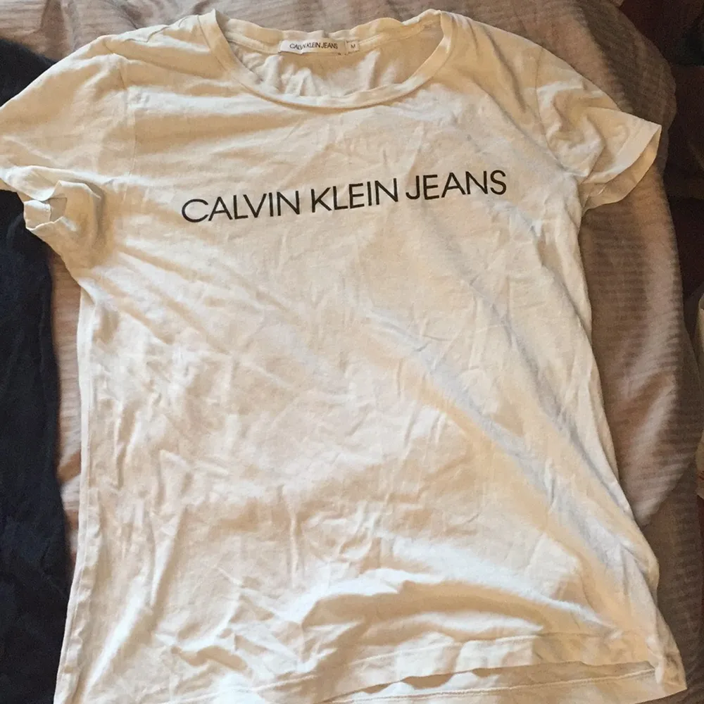 Två Calvin Klein thsirt, på den svart T-shirten är texten lite sprucken. . T-shirts.