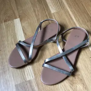 Minimalistiska sandaler med guldremmar från H&M