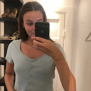 Blå topp med knappar - En superfin vardaglig topp som man även kan fixa upp till finare tillfällen! Toppen är aldrig använd och är i storlek L men som ni ser på bilden så sitter den väldigt bra på mig som är XS/S!