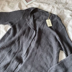 Grå Kofta - En snygg grå stickad kofta i storlek L. Jätteskön och aldrig använd. Lappen är fortfarande på. Skriv för fler frågor:)