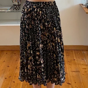 Plisserad kjol från Ginatricot  - Super somrig plisserad kjol från Ginatricot! Jag är ungefär 160 cm och kjolen går en bit över mina lår, men inte hela vägen ner till anklarna! 