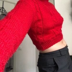 Röd stickad tröja  - En röd stickad tröja i croppad modell. Lite ribbat mönster framtill.