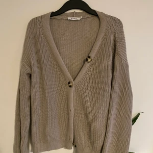 Stickad kofta - Jättegosig, lite oversize stickad kofta från NAKD. Färgen framkommer inte riktigt på bilden men den är typ grå/beige! Nästan som ny! Fraktar eller möts upp i Kalmar 💓