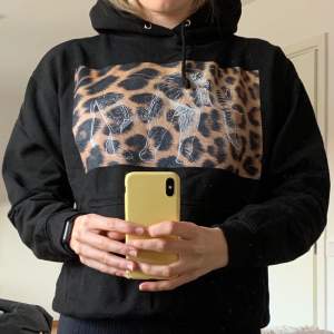 En svart cool elephant hoodie med ett leopardtryck på bröstet. På leopard trycket finns det en stor vit elefant☺️ Det finns även en ficka på magen! Den är i bra skick och är lite mindre i storleken än vanliga hoodies. Storlek M! Frakt står köparen för 💜😁 
