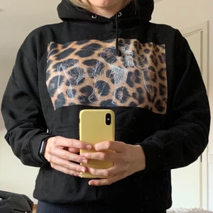 The cool Elephant Hoodie  - En svart cool elephant hoodie med ett leopardtryck på bröstet. På leopard trycket finns det en stor vit elefant☺️ Det finns även en ficka på magen! Den är i bra skick och är lite mindre i storleken än vanliga hoodies. Storlek M! Frakt står köparen för 💜😁 