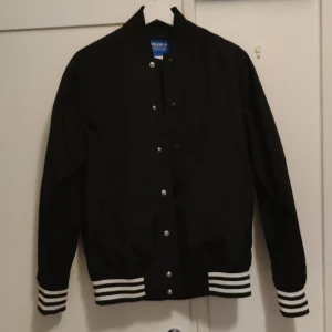 Adidas - Svart, tunn, baseballjacka från Adidas i stl S, herrmodell, och funkar snyggt oversize om så önskas! Perfekt nu till våren/sommaren. Mycket fint skick.
