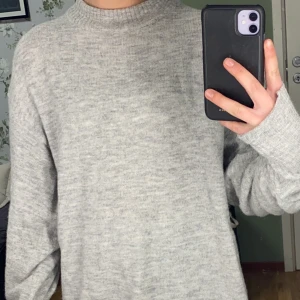 Gina Tricot tröja storlek S - Stickat grå lång tröja från Gina Tricot med krage och mudd i ärmen. Mysig men kan vara lite stickig utan någon tröja under. Går även att vika upp ifall man vill ha den kortare. Använd men i bra skick.