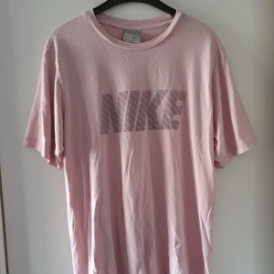 Vintage Nike t-shirt - Vintage ljusrosa Nike t-shirt i storlek L. Fraktkostnad blir 50kr. Om många är intresserade kan budgivning bli aktuellt.