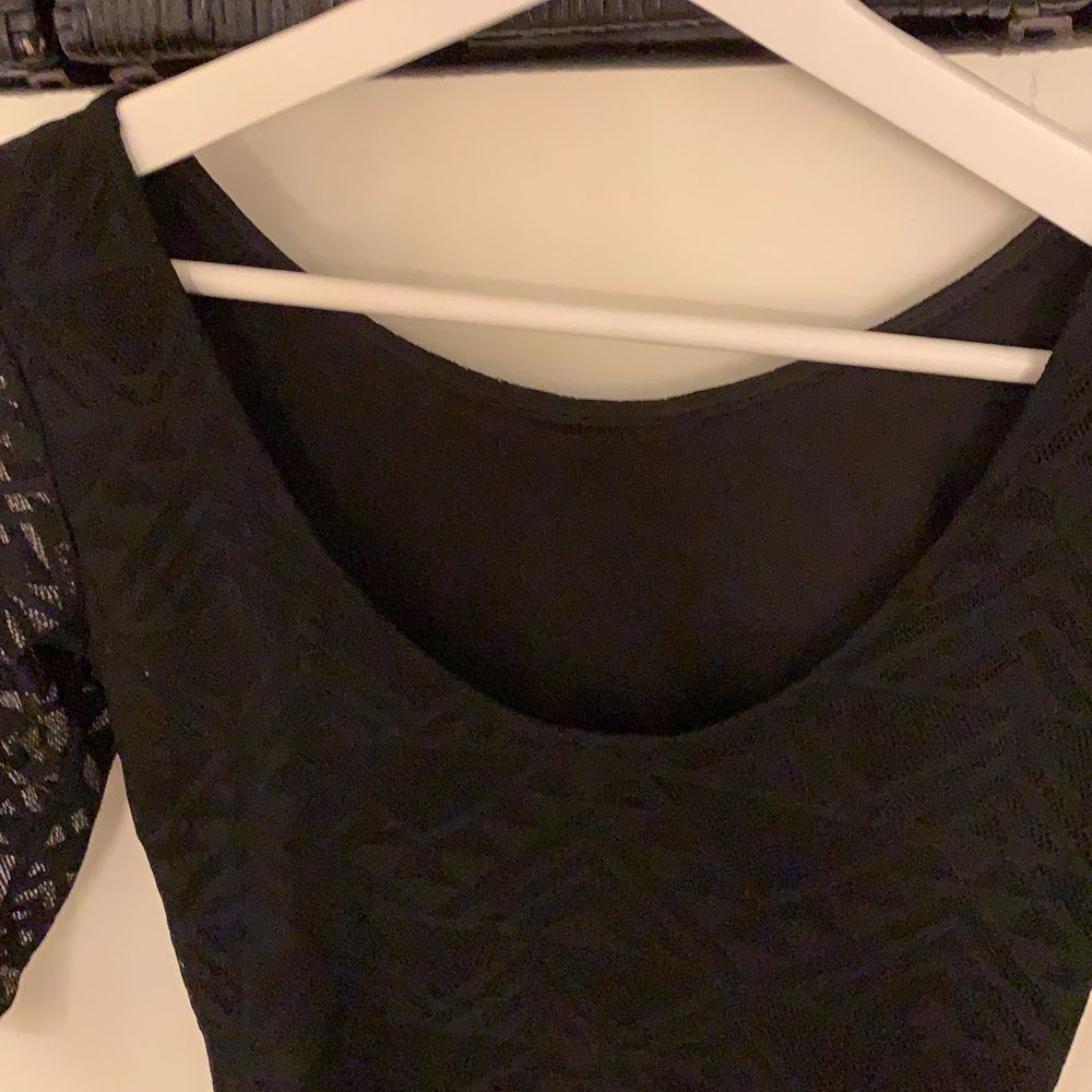 En svart klänning med trekvartsärmar, detaljer upptil och transparenta ärmar från H&M, divided, med tunt tyg nedtill. Strl 34.. Klänningar.
