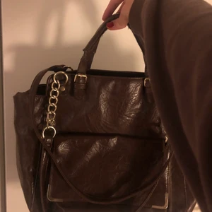 Brun väska - Brun skinnväska med guld detaljer. Går att ha både i handen, på en axel och crossover💓🥳