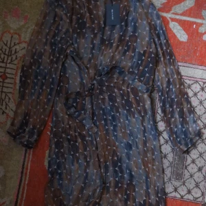 SAND ny omlottklänning, 46. - Geometrisk dekor i bruna toner. Ny, aldrig använd med lapp. Nypris 3700. 