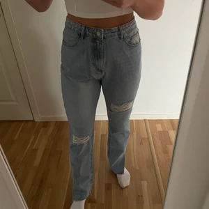 Blåa jeans med slitningar och slits - Svin snygga blåa jeans med slitningar och slits. Strl. 42 från missgiuded men ja skulle säga att den är lite liten i storleken. Helt oanvända med prislapp kvar. Önska verkligen jag kunde använda dom men köpte tyvärr fel storlek och säljer därför dom nu. Nypris 400 kr