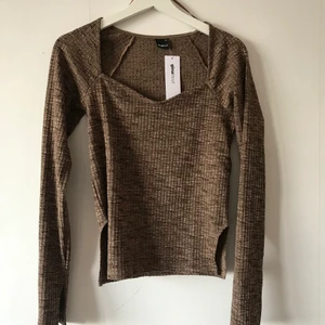 Brun tröja  - Brunspräcklig tröja med långa slitsade ärmar, liten slits på sidorna och vackert skuren halslinning. Helt ny! 