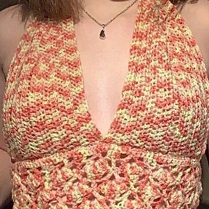 Virkad haltertop  - Orange/gul virkad topp med 100% akryl garn (kliar inte), toppen har snörning i ryggen så den passar nästan alla. Den är också mönstrad och knyts i nacken.