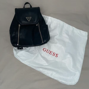 Guess läder ryggsäck  - Säljer min jättefina ryggsäck från märket Guess. Väskan är nästan helt oanvänd och i väldigt fint skick. Den är helt slutsåld och finns inte kvar att köpa. Väskan har två fack på sidorna och med små mindre fack på insidan. En dustbag tillkommer.