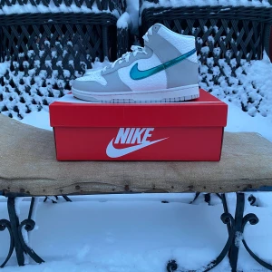 Nike Dunk High Ring Bling 41 - Hej, säljer ett par höga dunks i färgen Ring Bling storlek EU 41 / US 8  Helt nya och oanvända i sin låda med tillbehör samt kvitto. Perfekt nu inför våren med ett par nya och fräscha sneakers på uteserveringen!  Möts upp eller skickas dubbelboxad mot fraktkostnad. Har inte bråttom med att sälja men prutmån finns vid smidig affär.  Väl mött!